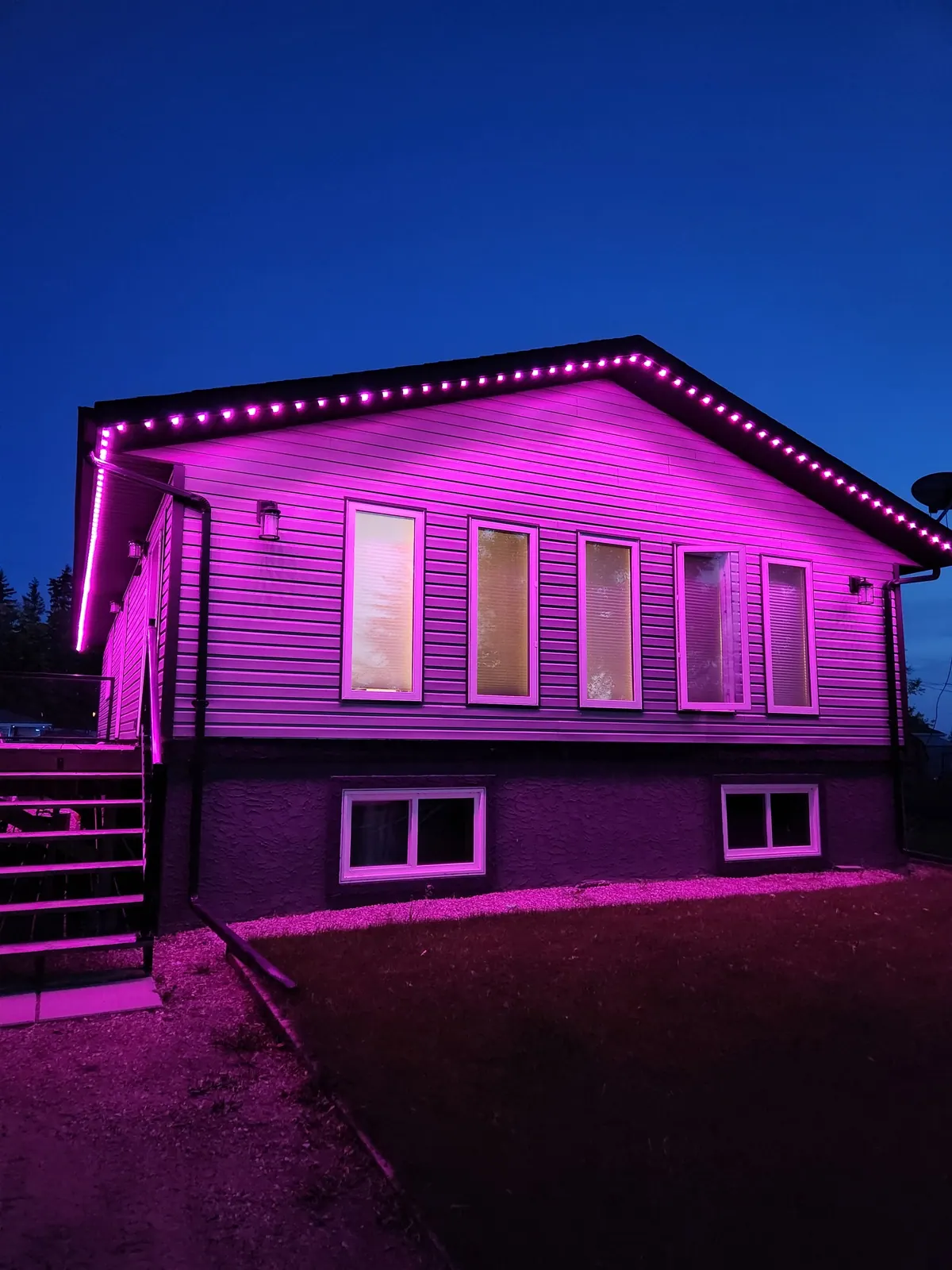 The same bungalow lit entirely in magenta pink by permanent LED lights - a Valentine's Day colour theme